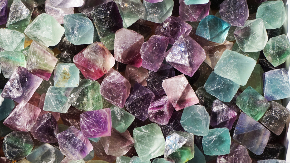 Close-up of colorful mineral crystals in shades of purple, green and blue, illustrating the diverse elements that make up mineral-rich soil.